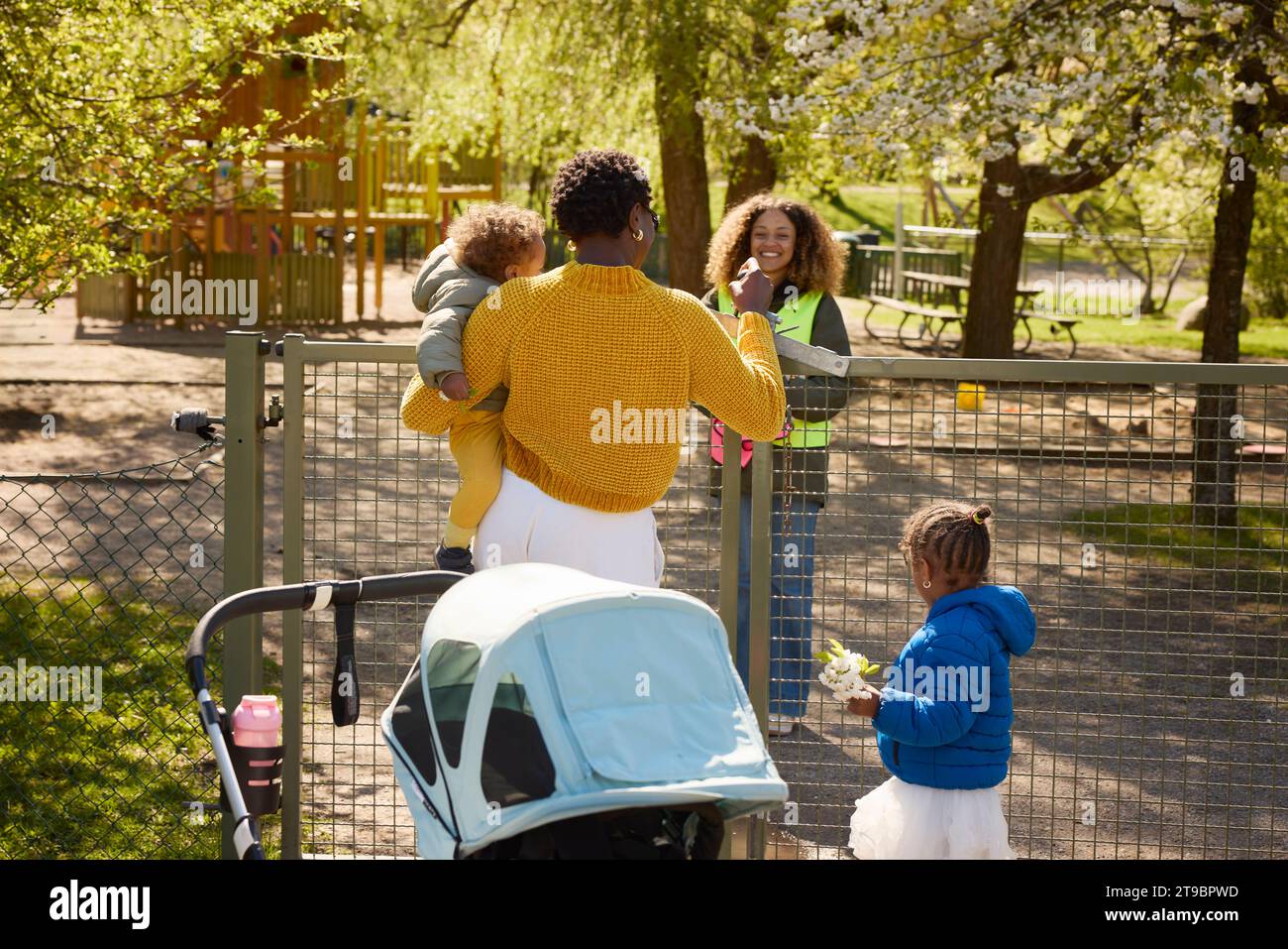 Mère avec deux filles dans le parc parlant au bénévolat Banque D'Images