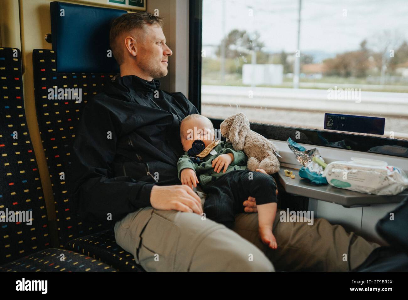 Père voyageant avec bébé en train Banque D'Images