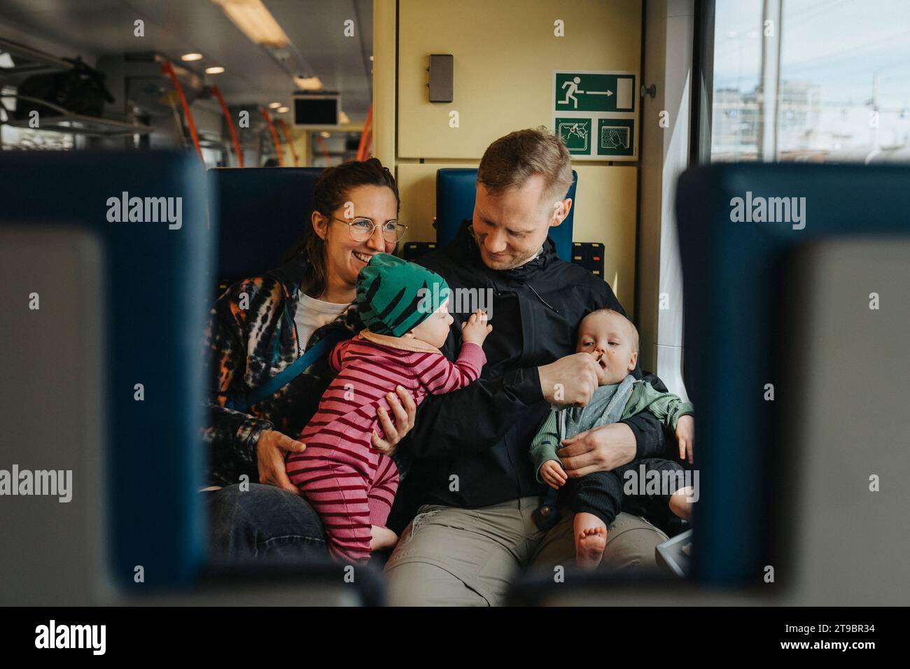 Parents voyageant avec des bébés en train Banque D'Images