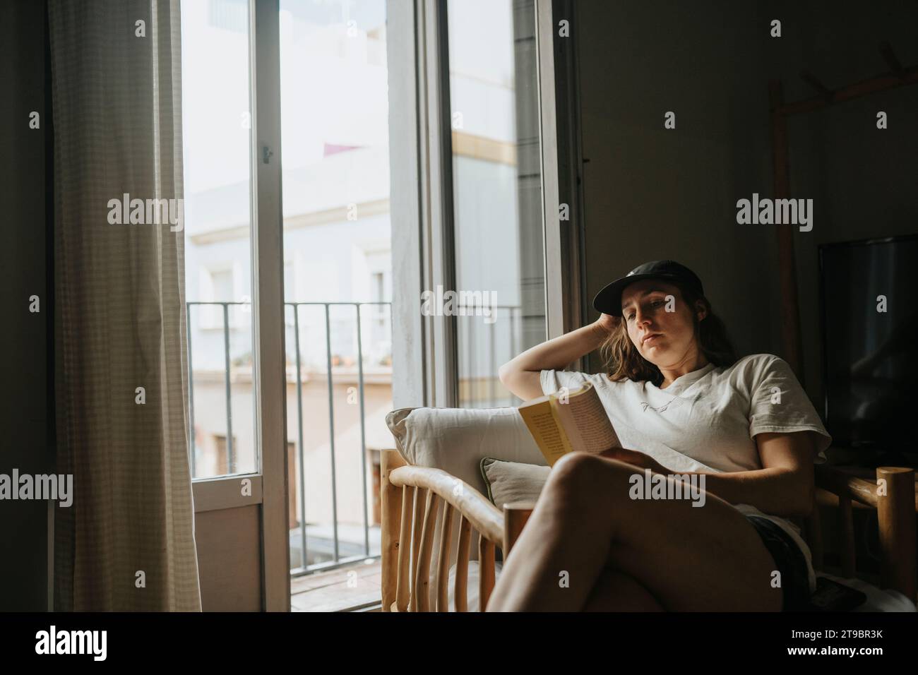 Femme se relaxant à la maison lisant le livre Banque D'Images