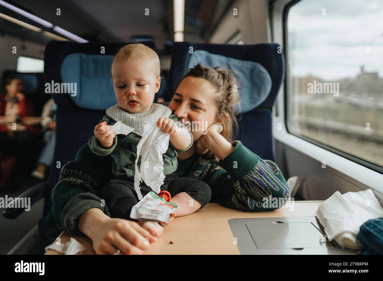 Femme voyageant avec bébé en train Banque D'Images