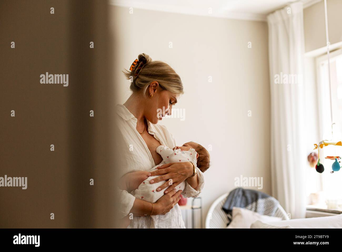 Mère allaitant son fils tout en restant à la maison Banque D'Images