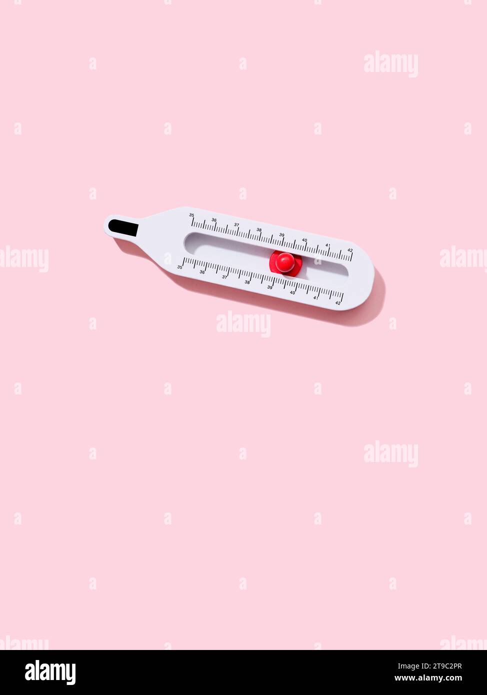 Thermomètre en bois jouet avec curseur rouge sur fond rose avec espace de copie Banque D'Images