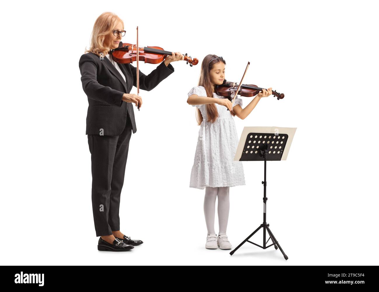 Fille pratiquant le violon avec une enseignante isolée sur fond blanc Banque D'Images