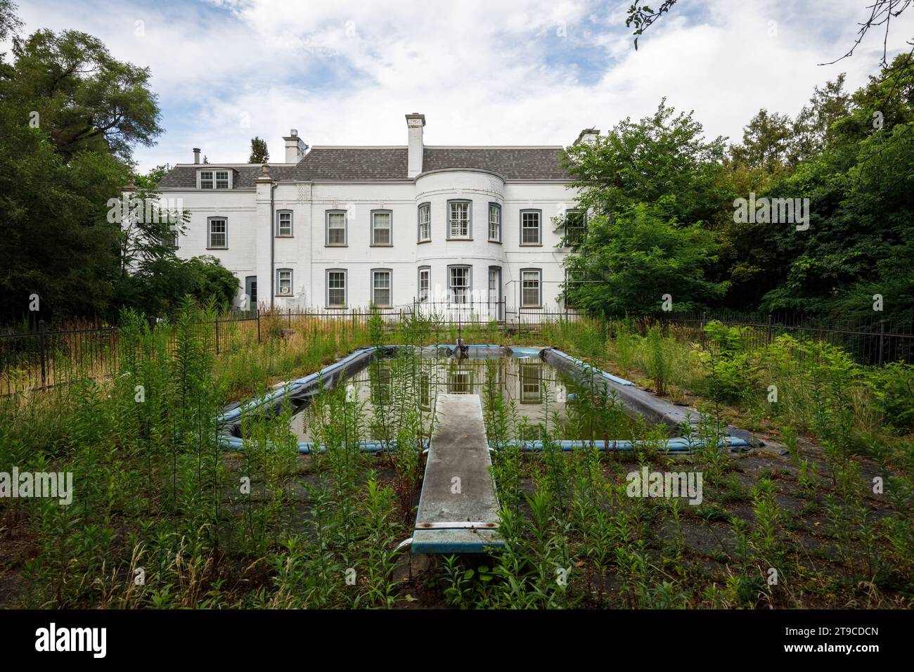 Une maison abandonnée de style néo-géorgien avec une piscine extérieure overgron. Banque D'Images