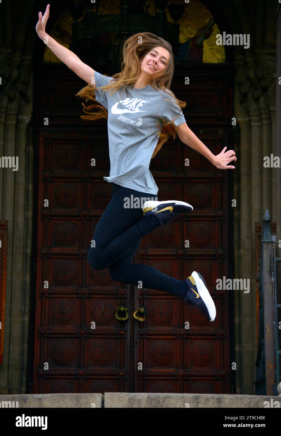 Jeune bulgare Pretty Girl porter de nouvelles chaussures de sport Nike chaussures courir Happy Jump porter T-shirt tee-shirt sauter devant l'église orthodoxe porte Sofia Bulgarie Banque D'Images