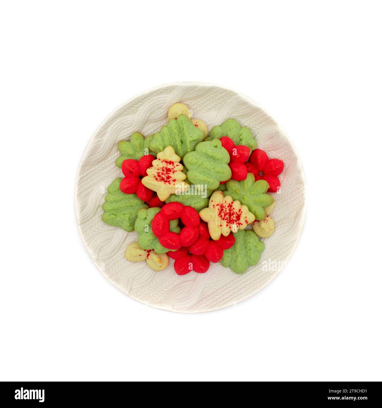 Plateau rond rempli de biscuits spritz de noël en rouge, vert et blanc avec du sucre de ponçage rouge en forme d'arbre, d'ornement et de fleur de poinsettia Banque D'Images