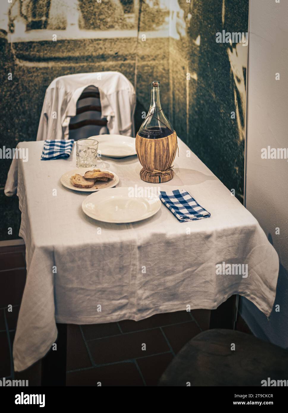 Vintage italien pauvre table set et une bouteille de vin. Scarperia, Florence, Toscane. Banque D'Images