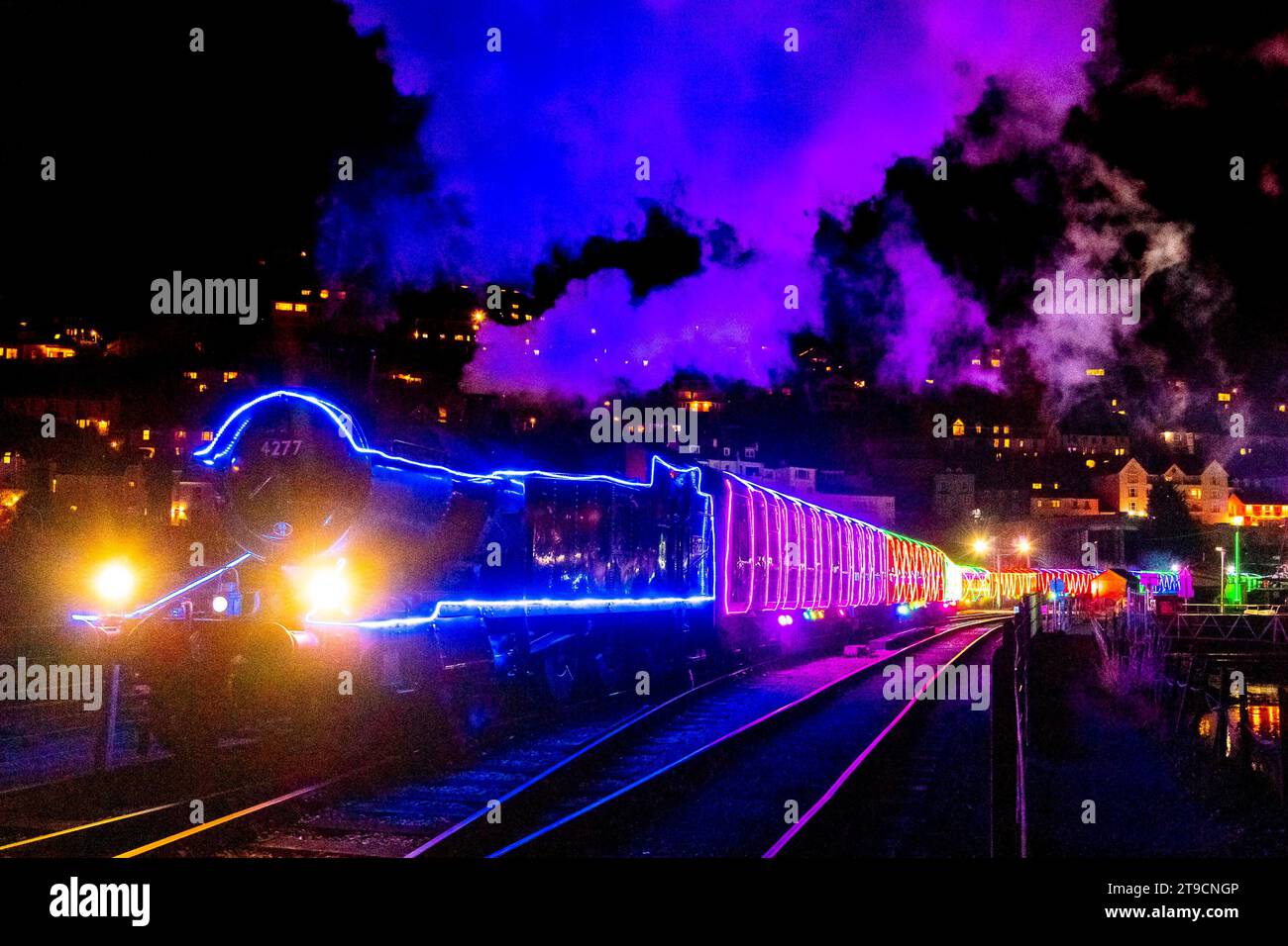 Kingswear, Devon, Royaume-Uni. 24 novembre 2023. Le train des Lumières de Noël sur le chemin de fer à vapeur de Dartmouth qui circule entre le 24 novembre et le 30 décembre 2023, sort de la station Kingswear dans le Devon pour se rendre à Paignton. Les voitures et les locomotives à vapeur du service festif sont éclairées à l'intérieur et à l'extérieur avec des lumières colorées. Crédit photo : Graham Hunt/Alamy Live News Banque D'Images