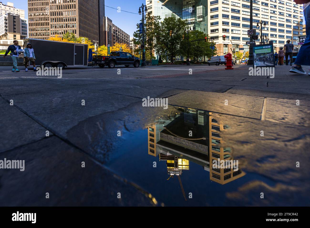 Un nouveau bâtiment de grande hauteur se reflète dans une flaque d'eau sur le campus de Martius Park à Detroit, aux États-Unis Banque D'Images