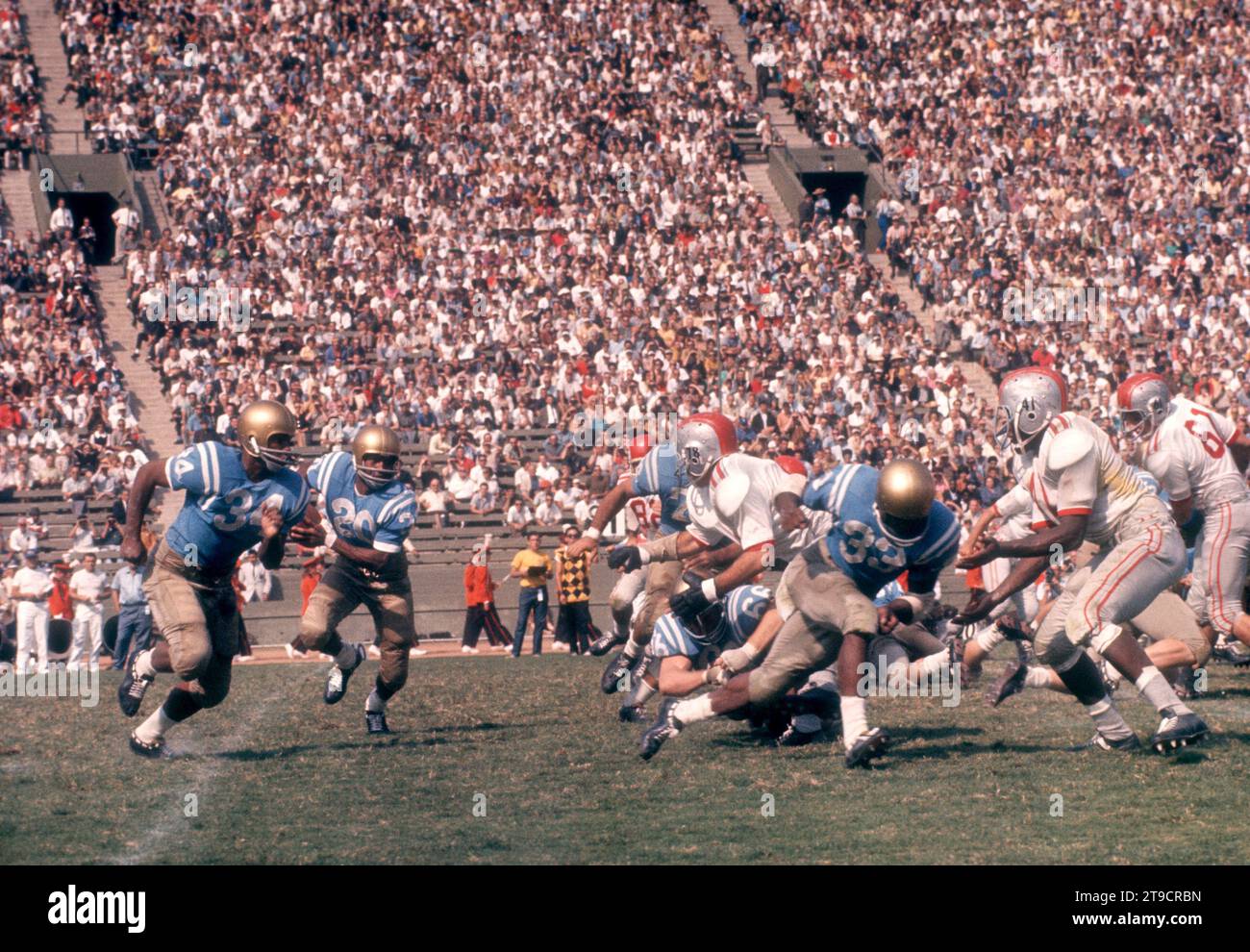 LOS ANGELES, CA - 6 OCTOBRE : le quarterback Ezell Singleton #20 des Bruins de l'UCLA court avec le ballon alors que Warren Jackson #34 bloquera lors d'un match de la NCAA contre les Buckeyes de l'Ohio State le 6 octobre 1962 au Los Angeles Memorial Coliseum à Los Angeles, Californie. (Photo de Hy Peskin) *** Légende locale *** Warren Jackson;Ezell Singleton Banque D'Images