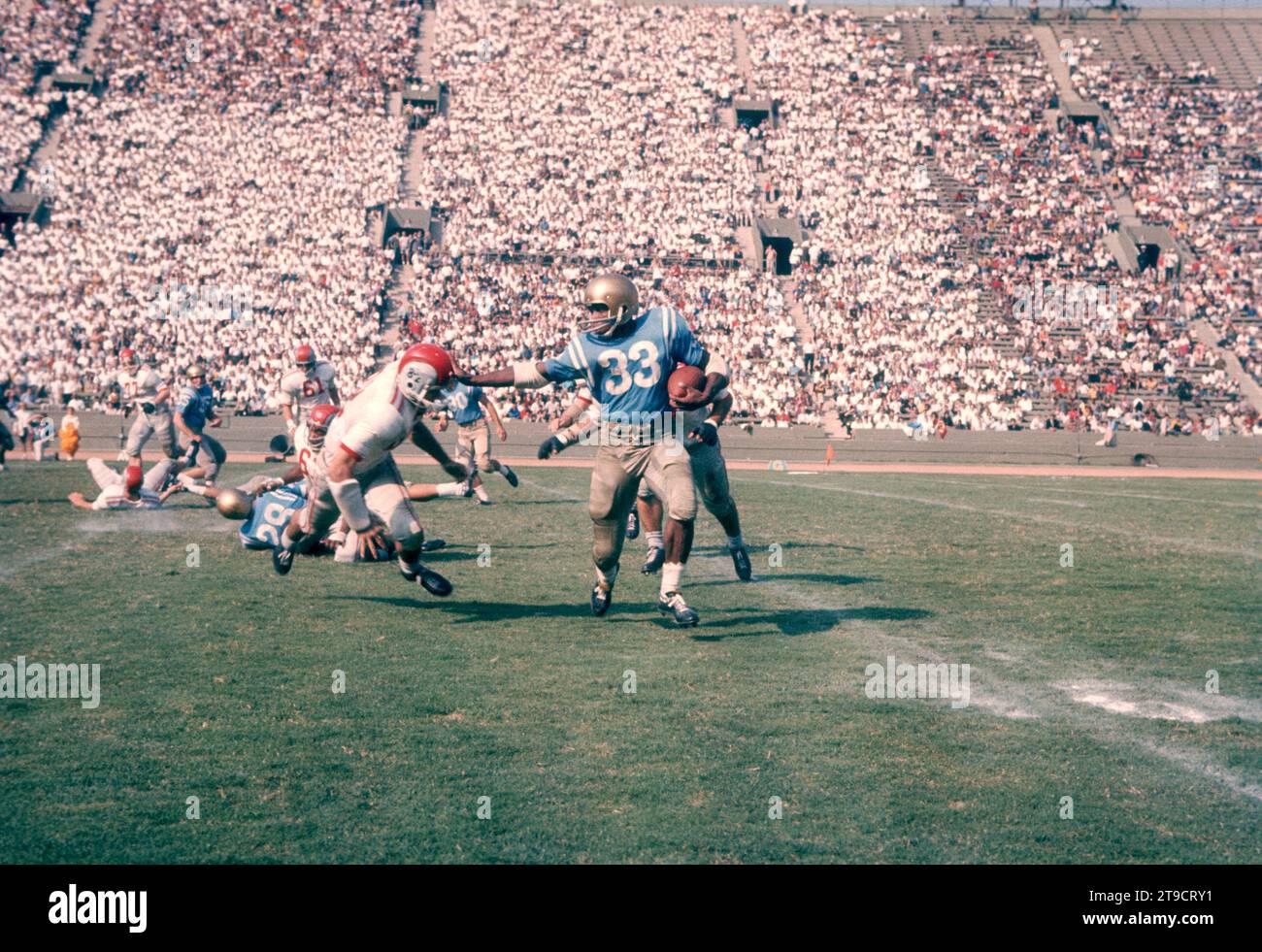 LOS ANGELES, CA - 6 OCTOBRE : Kermit Alexander #33 des Bruins de l'UCLA court avec le ballon en tant que Daniel Porretta #78 et William Spahr #82 des Ohio State Buckeyes lors d'un match de la NCAA le 6 octobre 1962 au Los Angeles Memorial Coliseum à Los Angeles, Californie. (Photo de Hy Peskin) *** Légende locale *** Kermit Alexander;Daniel Porretta;William Spahr Banque D'Images