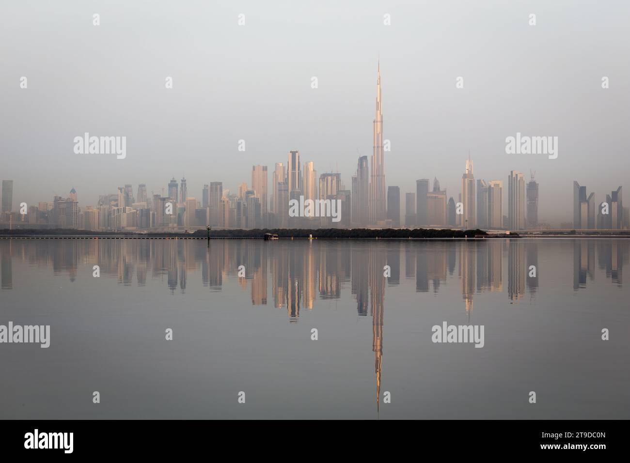 Paysage d'horizon du centre-ville de Dubaï avec les gratte-ciel reflétant le soleil doré et les reflets dans la crique de Dubaï, lever du soleil. Banque D'Images