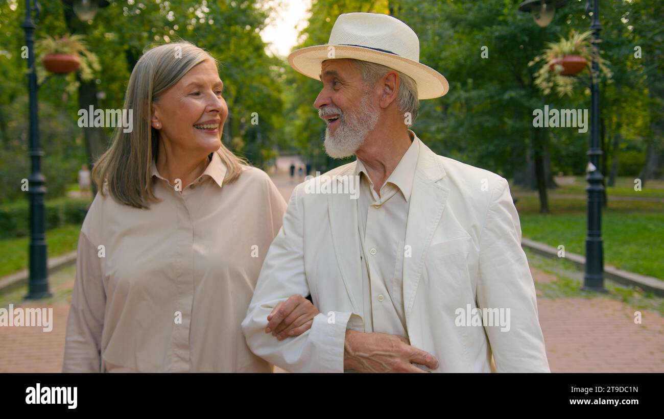 Close up famille heureuse caucasien romantique senior couple femme mari homme femme marchant à l'extérieur du parc de la ville parler discuter sourire rire week-end Banque D'Images