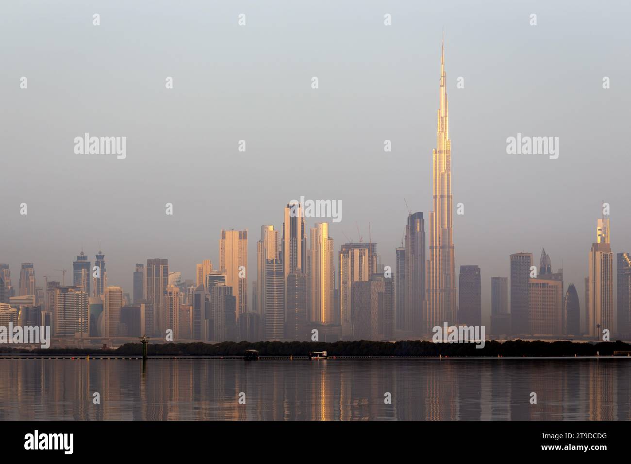 Paysage d'horizon du centre-ville de Dubaï avec les gratte-ciel reflétant le soleil doré et les reflets dans la crique de Dubaï, lever du soleil. Banque D'Images