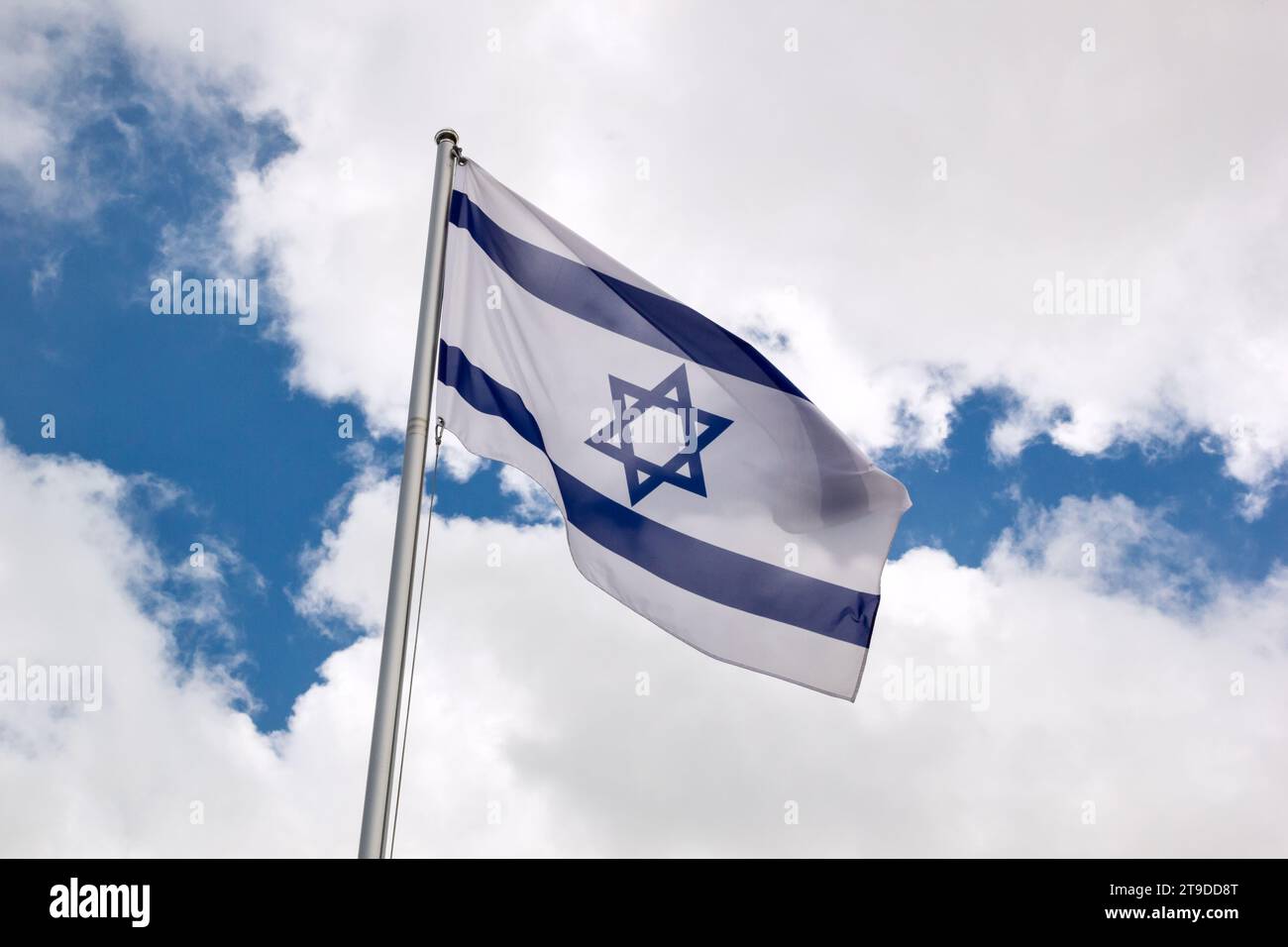 Drapeau d'Israël agitant dans le vent sur mât de drapeau contre le ciel avec des nuages sur la journée ensoleillée, gros plan Banque D'Images