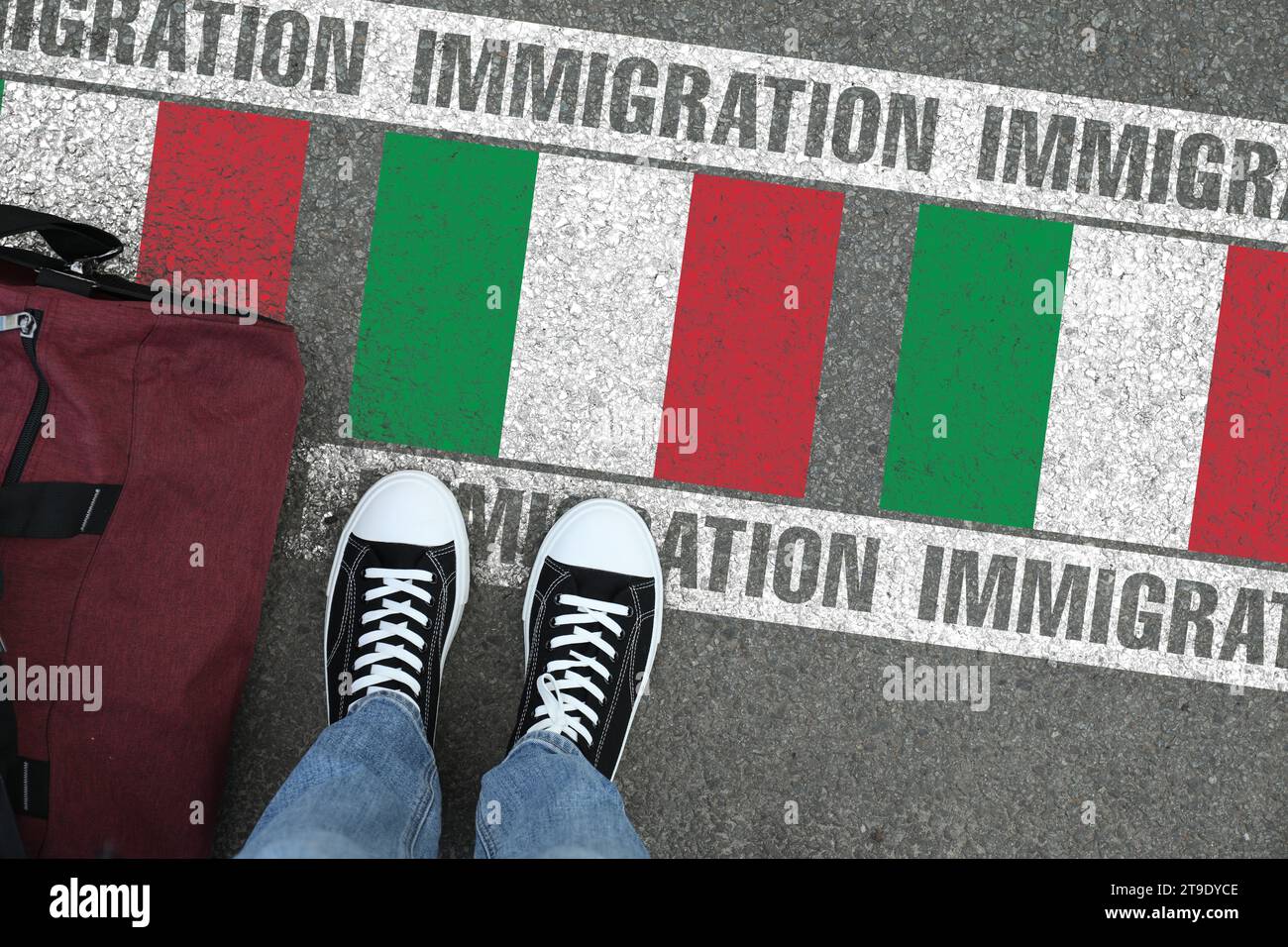 Immigration. Homme avec sac debout sur l'asphalte près du drapeau de l'Italie, vue de dessus Banque D'Images