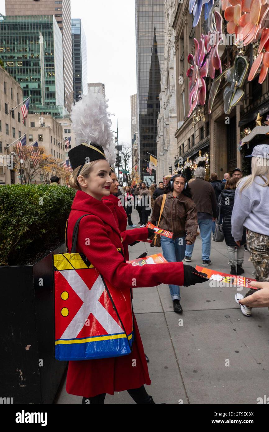 Jeune femme, en costume, distribue des dépliants pour le Christmas Spectacular et radio City Music Hall, 2023, New York City, USA Banque D'Images