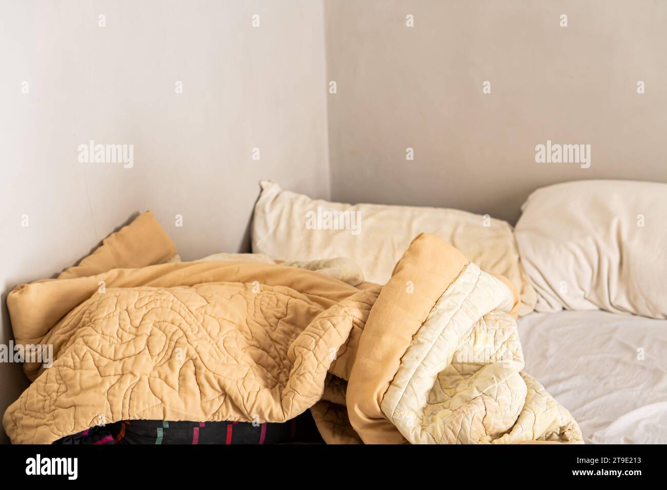Lit en désordre avec oreiller blanc et couverture avec lumière naturelle dans la chambre le matin Banque D'Images