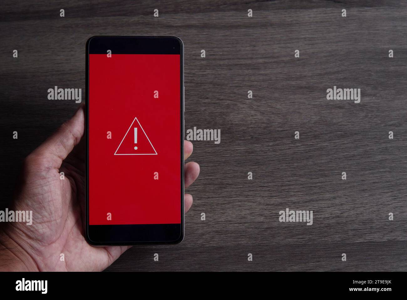 Smartphone avec icône d'avertissement triangle. Copier l'espace pour le texte. Erreur système, malware et concept de cybercriminalité. Banque D'Images