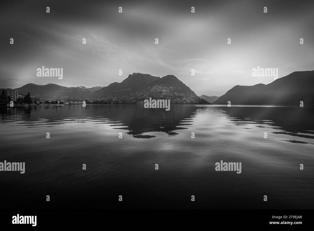 Panorama noir et blanc sur le lac de Lugano et la ville en automne tôt le matin Banque D'Images