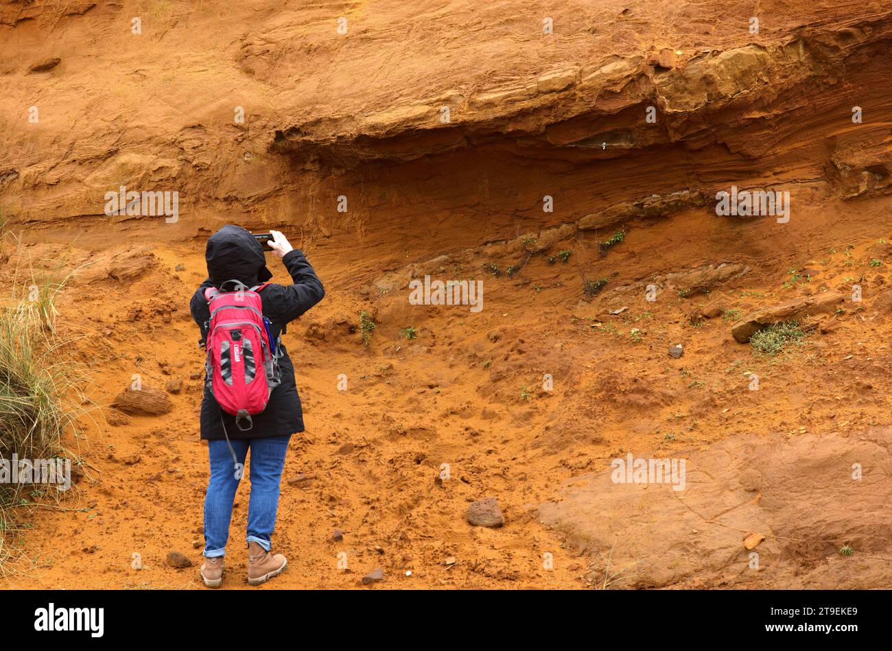 Femme, randonneur avec sac à dos photographié, roche rougeâtre de limonite, géotope Morsum-Kliff, Morsum, île de la mer du Nord Sylt, Frise du Nord Banque D'Images