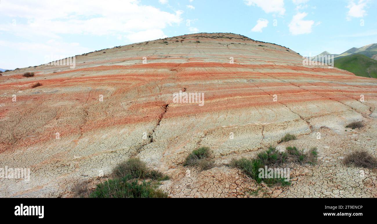 Montagnes avec des rayures rouges et de l'herbe verte. Région de Khizi. Azerbaïdjan. Banque D'Images