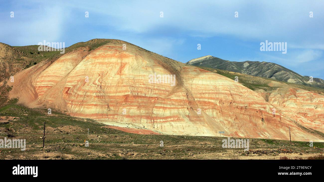 Montagnes avec des rayures rouges et de l'herbe verte. Région de Khizi. Azerbaïdjan. Banque D'Images