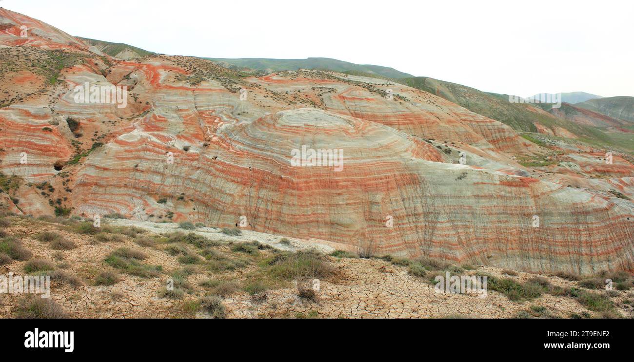 Montagnes avec des rayures rouges et de l'herbe verte. Région de Khizi. Azerbaïdjan. Banque D'Images