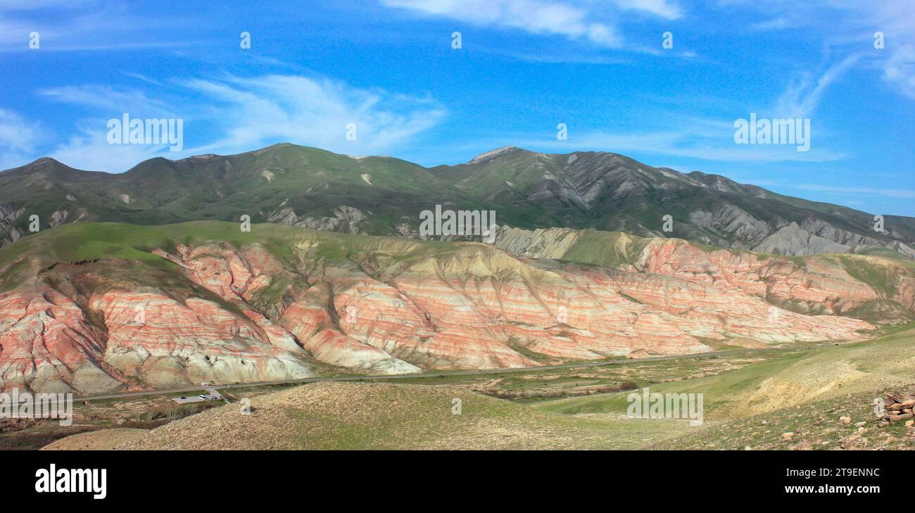 Montagnes avec des rayures rouges et de l'herbe verte. Région de Khizi. Azerbaïdjan. Banque D'Images
