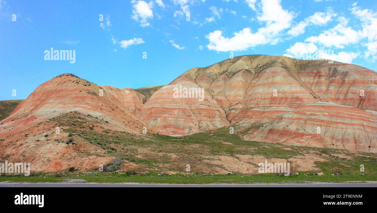 Montagnes avec des rayures rouges et de l'herbe verte. Région de Khizi. Azerbaïdjan. Banque D'Images