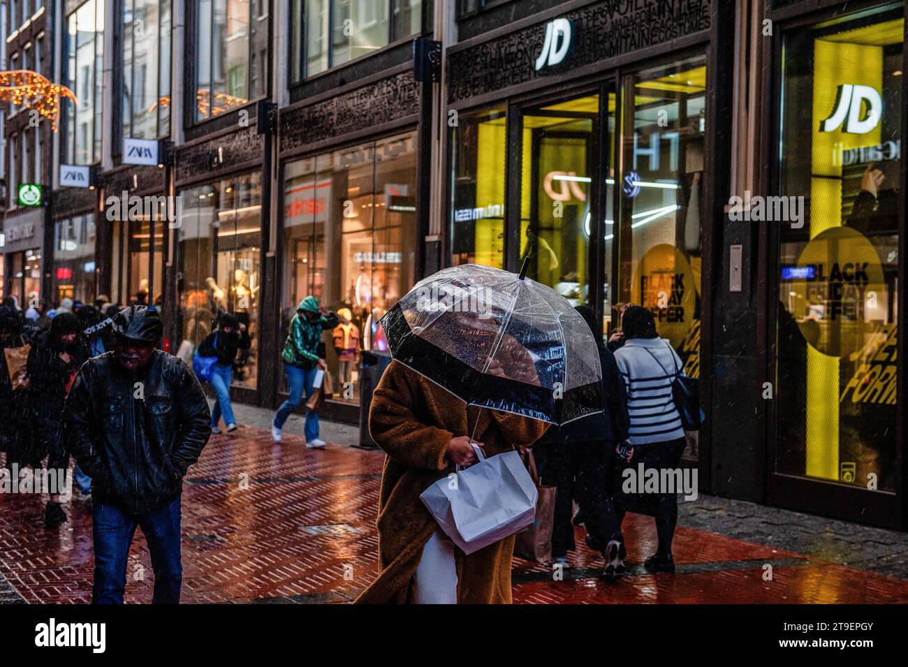 Amsterdam, pays-Bas. 24 novembre 2023. Une personne vue avec un parapluie pendant une forte tempête. À Amsterdam, les magasins sont prêts avec des offres Black Friday, et les vitrines des magasins sont décorées avec des bannières de vente pour attirer les gens pendant le Black Friday. Les plus jeunes, en particulier, attendent le jour de réduction après Thanksgiving de l'Amérique pour acheter des choses. (Photo Ana Fernandez/SOPA Images/Sipa USA) crédit : SIPA USA/Alamy Live News Banque D'Images