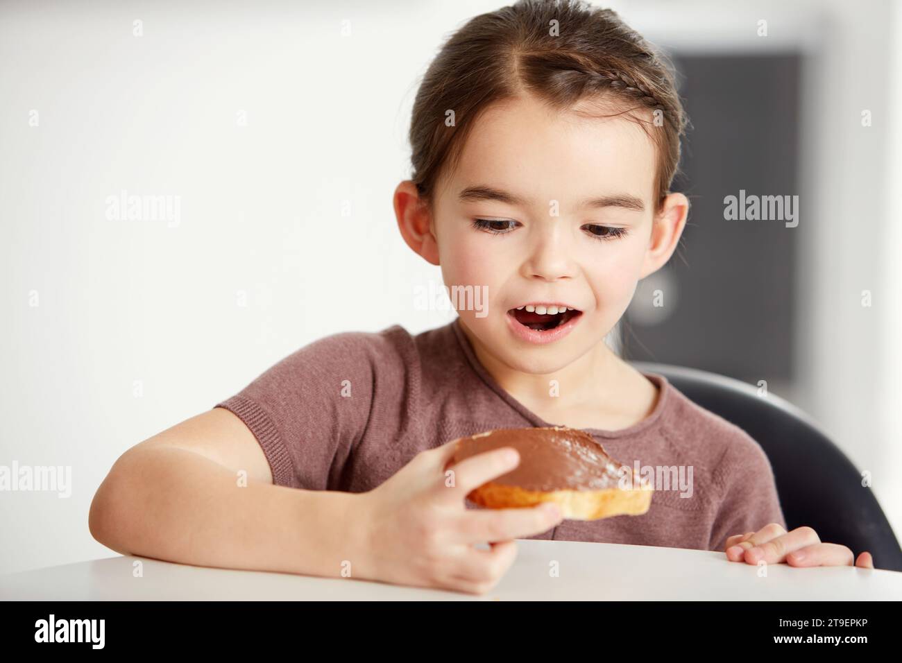 Petite fille, pain grillé et chocolat à tartiner pour une collation sucrée, délicieuse ou déserte sur du pain dans la cuisine à la maison. Jeune femme, enfant ou enfant dans Banque D'Images