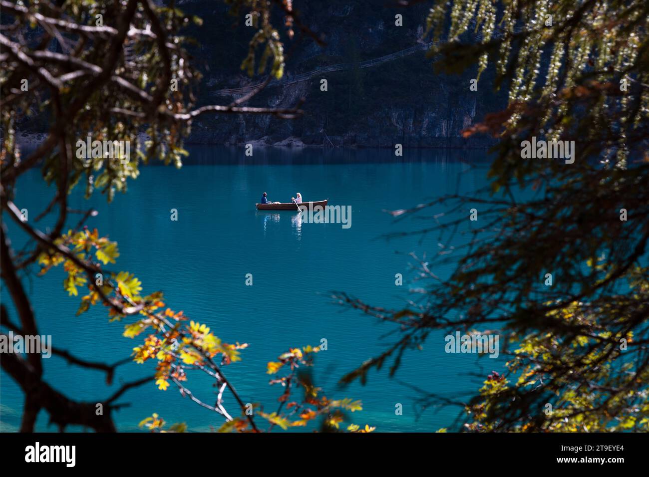 Vue romantique du bateau sur le magnifique lac bleu encadré par des arbres en forme de coeur. Paire sur le bateau en bois sur le Lago di Braies dans les Dolomites Banque D'Images