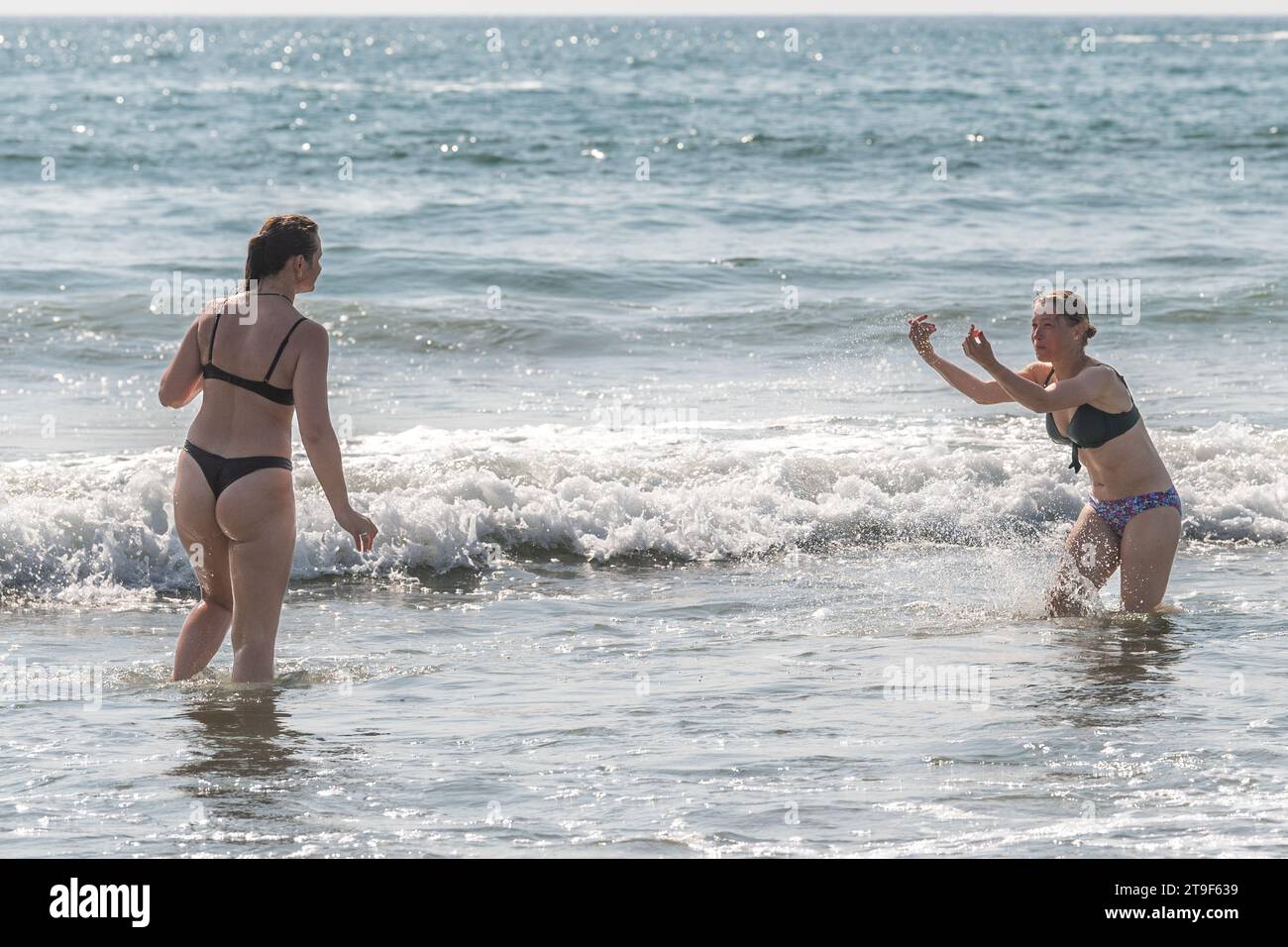 Deux femmes vêtues de bikini s'amusent dans la mer à Warren Beach, Rosscarbery, West Cork, Irlande. Banque D'Images