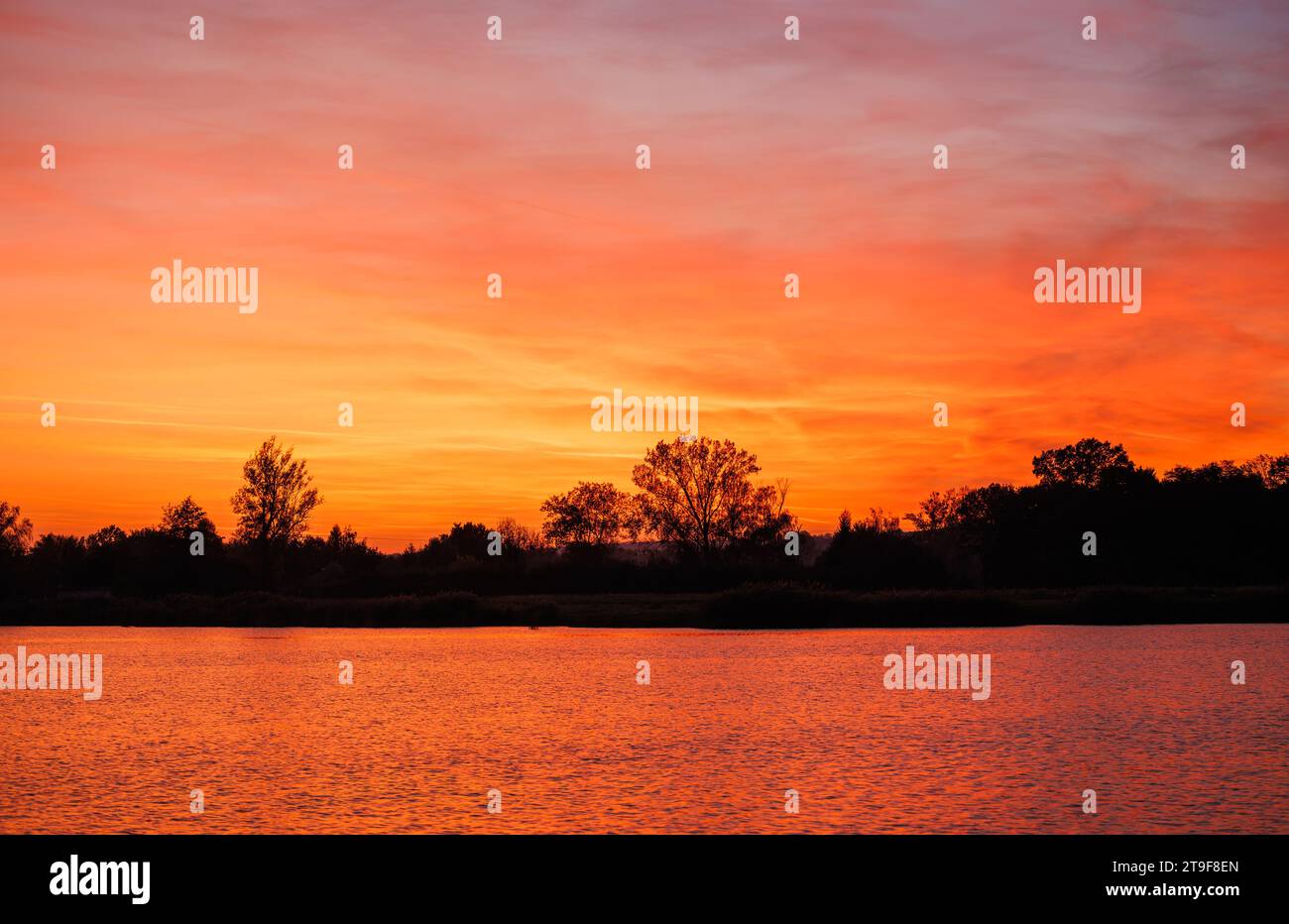 Réflexion du beau ciel orange coucher de soleil sur le lac de surface de l'eau. Paysage de la nature avec espace de copie Banque D'Images