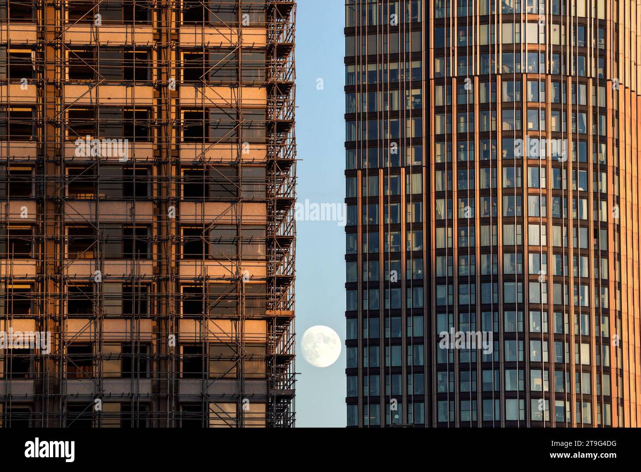Londres, Royaume-Uni. 25 novembre 2023. UK Météo : 96.3% cire Gibbous lune est vu se lever au-dessus de la ville entre deux bâtiments par un après-midi clair. Crédit : Guy Corbishley/Alamy Live News Banque D'Images