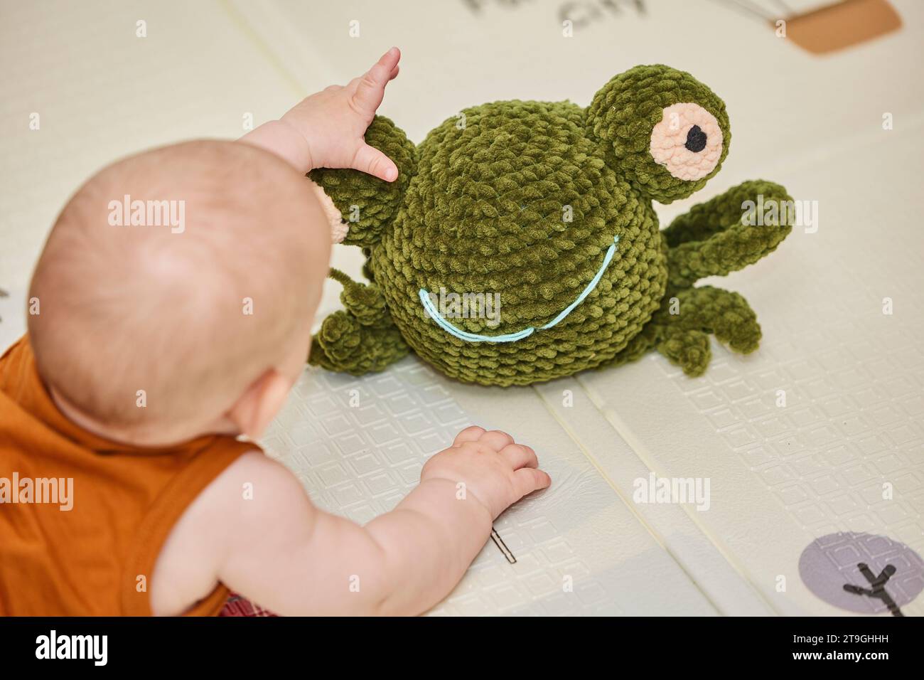 bébé joue avec un jouet tricoté dans la pépinière Banque D'Images