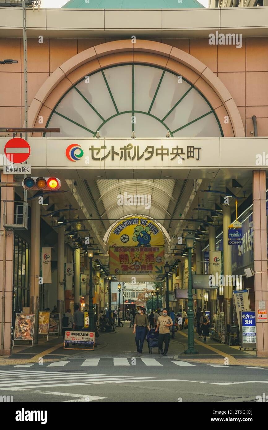Une scène de rue animée de la ville avec une variété de personnes marchant à l'extérieur d'une rangée de magasins pendant la journée Banque D'Images
