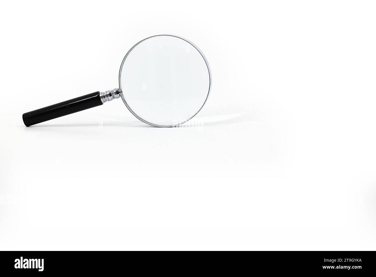 Une image d'une loupe avec une poignée noire et un rebord argenté autour de la loupe, sur un fond blanc immaculé. Banque D'Images