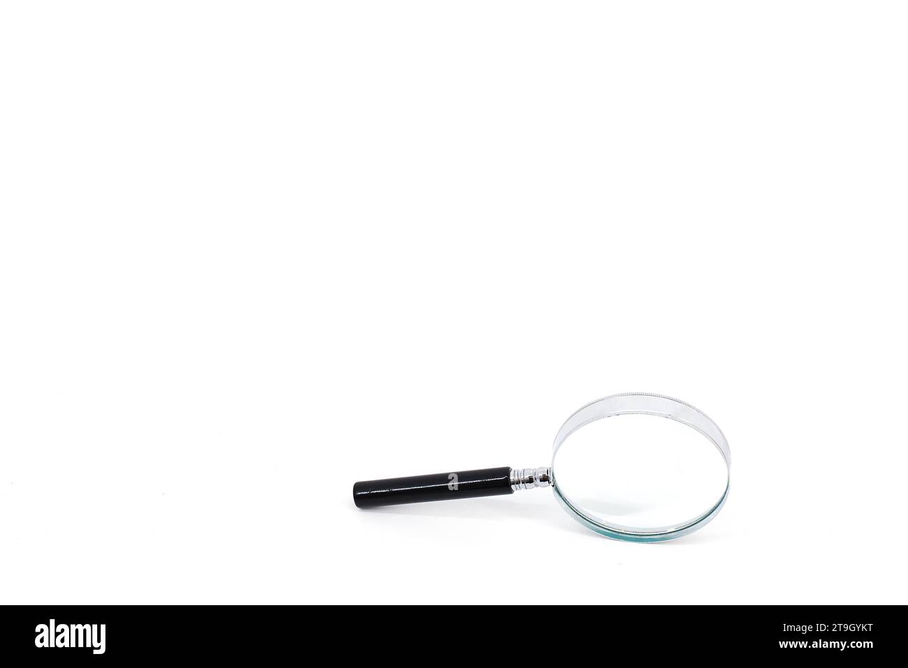 Une image d'une loupe avec une poignée noire et un rebord argenté autour de la loupe, sur un fond blanc immaculé. Banque D'Images