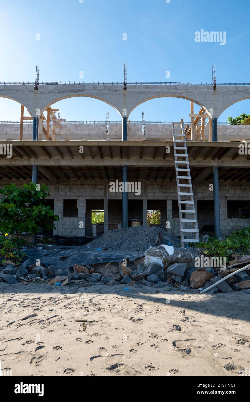 Maison en construction sur la plage avec divers matériaux, échelles et pourriels Banque D'Images