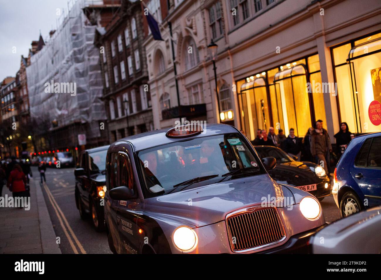 London taxi passant par Regent Street à Londres la nuit avec des magasins éclairés et les gens flous dans l'arrière-plan pendant l'heure de pointe en 2013 Banque D'Images