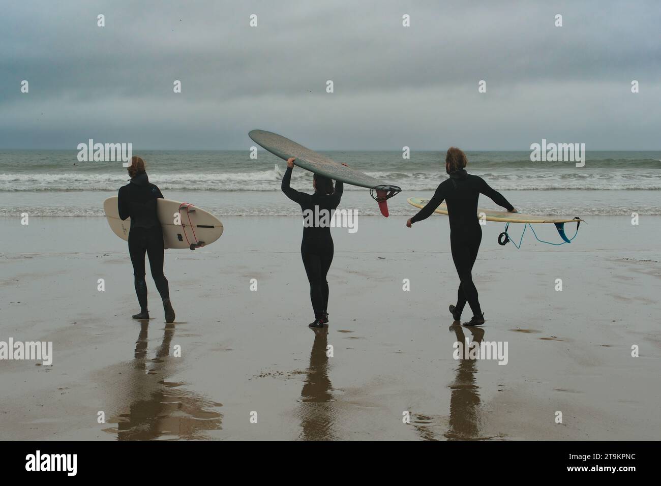 Polzeath, Cornouailles, Royaume-Uni. 26 novembre 2023. UK Météo. C'était un jour gris mizzly sur la plage de Polzeath, mais doux pour cette période de l'année pour ce trio aller surfer un dimanche. Crédit Simon Maycock / Alamy Live News. Banque D'Images