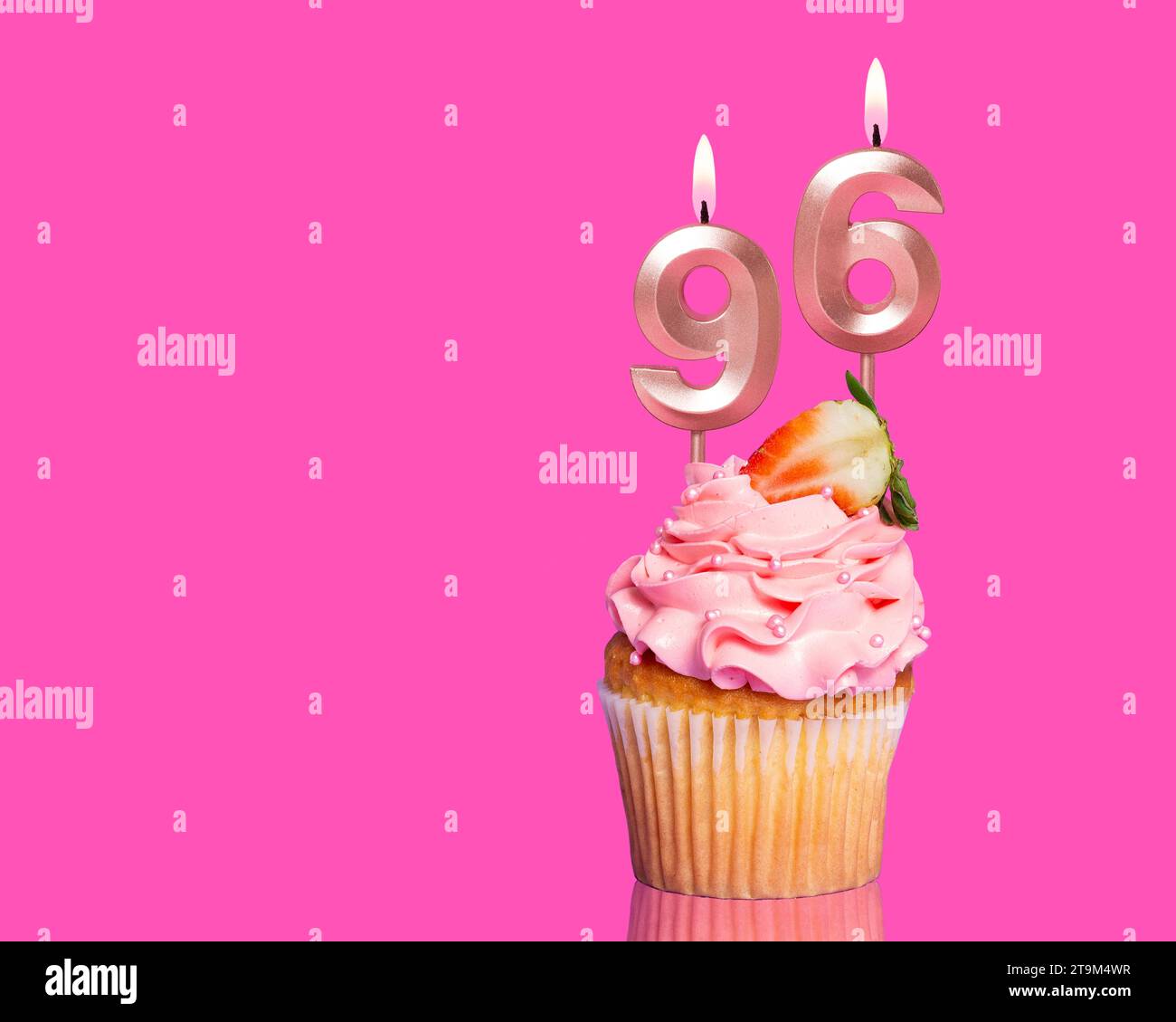 Cupcake d'anniversaire avec bougie numéro 96 - sur fond rose chaud. Banque D'Images