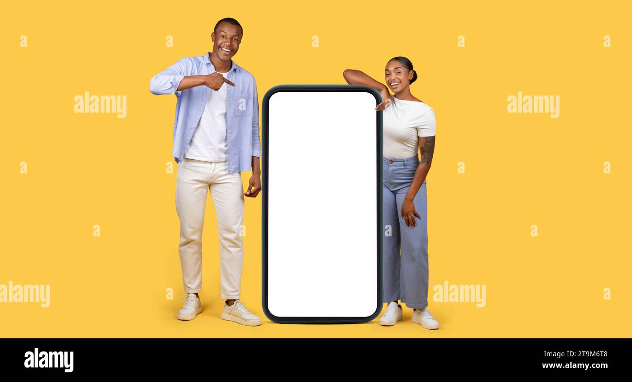 Couple pointant vers l'écran géant de téléphone portable, bannière Banque D'Images