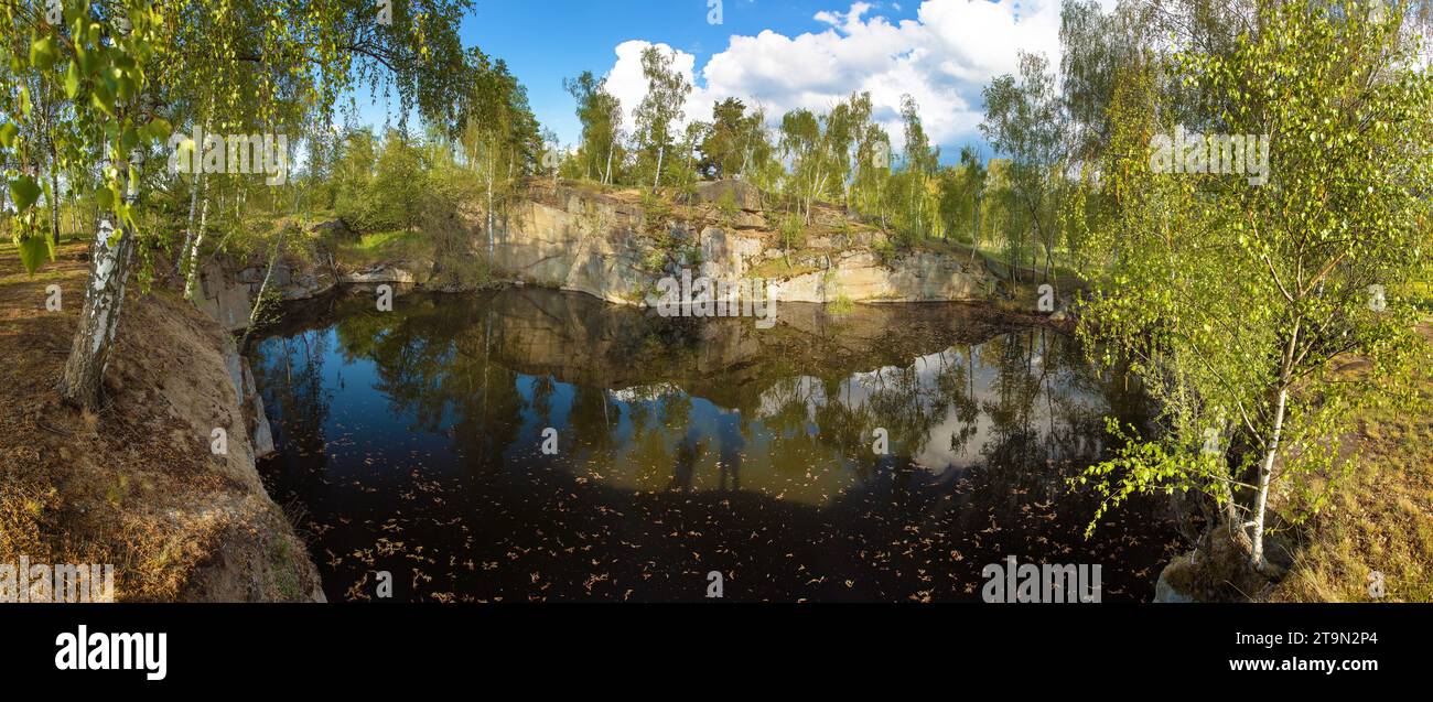 Lac avec mur de roche et forêt de bouleau se reflétant dans le lac Banque D'Images