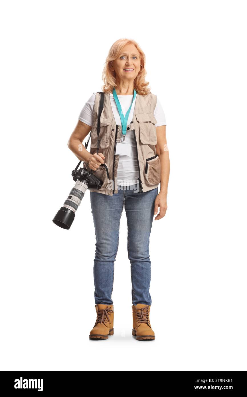 Portrait en longueur d'une photographe féminine portant un appareil photo professionnel et souriant isolé sur fond blanc Banque D'Images