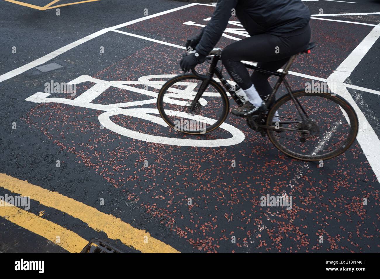 Cycliste faisant du vélo sur un marquage de piste cyclable. Banque D'Images