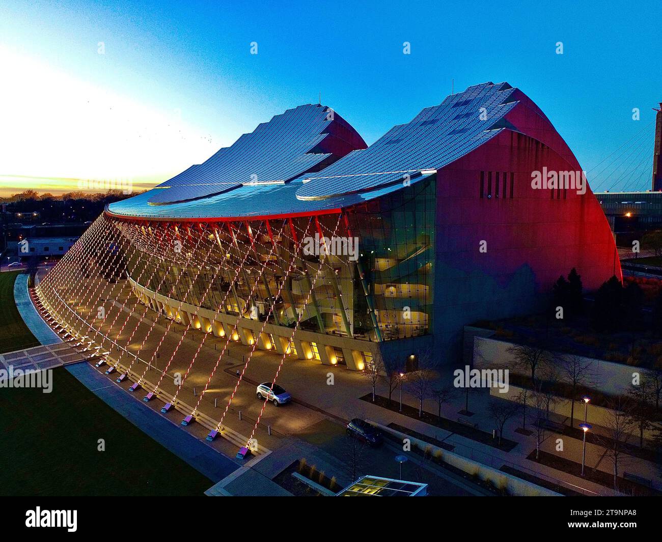 Un bâtiment de pavillon de verre illuminé se dresse majestueusement sur le côté de la rue avec ses lumières brillantes rayonnant dans toute la zone Banque D'Images